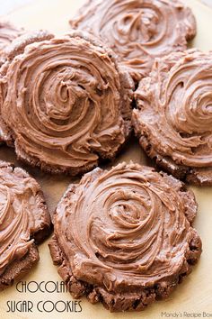 chocolate sugar cookies with frosting on a cutting board