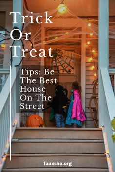 two children standing on the front steps of a house decorated with halloween decorations and lights