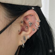 a woman with many piercings on her ear