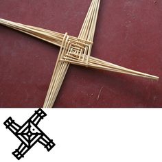 a cross made out of bamboo sticks sitting on top of a red floor next to a black and white sign