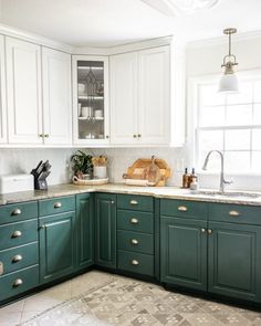 a kitchen with green cabinets and white walls