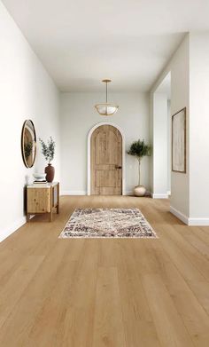 an empty room with wood floors and white walls