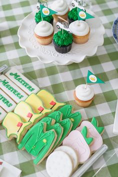 cupcakes and cookies are on the table for a golf themed birthday party,