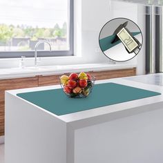 a bowl of fruit sitting on top of a kitchen counter