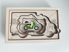 a wooden puzzle with a green scooter on it's front and side