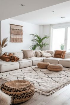 a living room filled with lots of white furniture and pillows on top of a rug