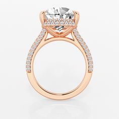 a rose gold engagement ring with an oval center stone surrounded by pave set diamonds