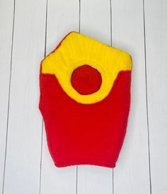 a red and yellow purse sitting on top of a white wooden floor