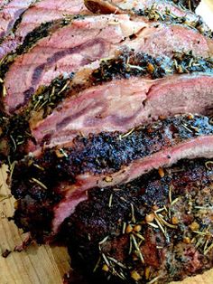 sliced meat sitting on top of a wooden cutting board