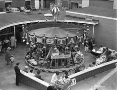 an old black and white photo of people around a carousel