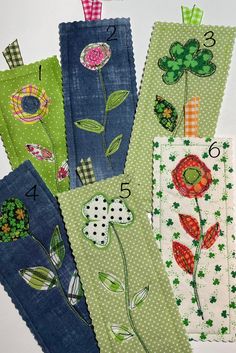 four handmade bookmarks with flowers and numbers on them are lined up in rows