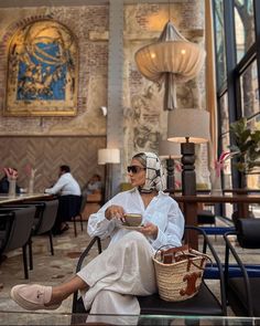 a woman sitting in a chair holding a bowl