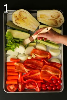 someone is cutting up vegetables on a tray