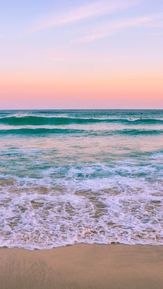 an ocean view with waves coming in to shore and a pier sticking out from the water