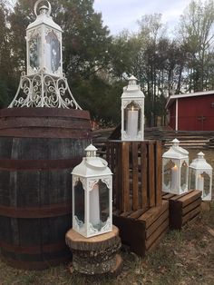 several white lanterns sitting on top of wooden barrels