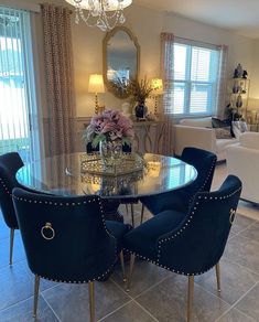 a dining room table with blue chairs and a chandelier hanging from the ceiling