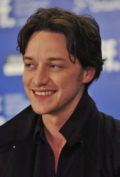 a man smiling and wearing a black shirt