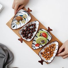 three people holding plates with food on them and one person reaching for the platter