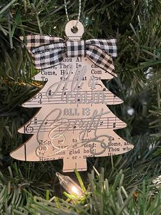 a wooden ornament hanging from a christmas tree decorated with musical notes and a bow