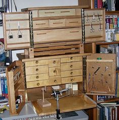 a wooden cabinet with drawers and tools on it in a room full of bookshelves