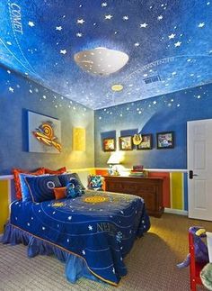 a bedroom decorated in blue, yellow and orange with stars on the ceiling above the bed