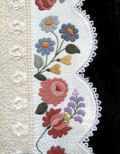 an embroidered piece of cloth with flowers on it