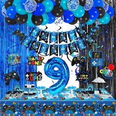 a birthday party with blue and black balloons, streamers, decorations and table cloths