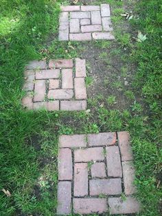 three brick walkways in the grass on a sunny day