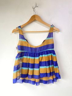 Vintage Miu Miu Striped Silk Top. Very delicate and so cute for summer! Features tan and blue stripes throughout with a purple and white cotton applique across the chest. Snap closures along the side. 100% silk, made in Italy. Marked a size 40, would best fit XS/S. In overall great vintage condition with some wear along the bust seam, refer to photos for more info. Approx. Measurements: Underarm to Underarm: 16" Length: 21" Silk Fitted Top For Beach, Fitted Silk Beach Top, Fitted Silk Top For Beach, Fitted Silk Top For The Beach, Sleeveless Silk Beach Top, Sleeveless Silk Tops For Beach, Sleeveless Silk Tops For The Beach, Striped Summer Beach Top, Multicolor Silk Beach Top