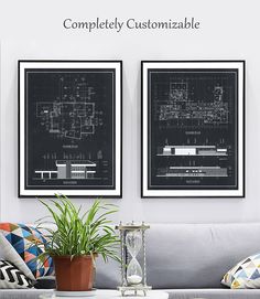 two framed blueprints hang on the wall above a couch with a potted plant