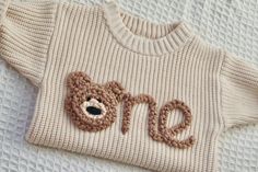 a knitted teddy bear sweater with the word otn written on it's chest