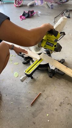 a person working on a piece of wood with a circular sawtoothing machine in the background