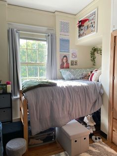 a small bedroom with a bed, dresser and window in it's center area