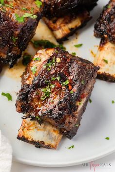 grilled ribs on a plate with garnishes and parmesan cheese