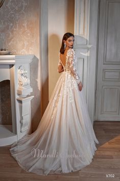 a woman in a wedding dress standing next to a fireplace