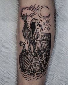 a man's leg with a boat and moon tattoo on it