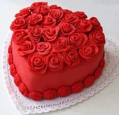 a heart shaped cake with red roses on it