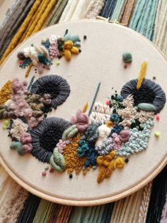 a close up of a embroidery on a piece of cloth with scissors and needles in it