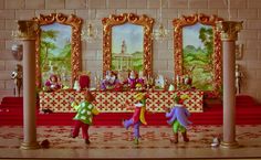 three little kids are playing in front of an altar with paintings on the wall behind them