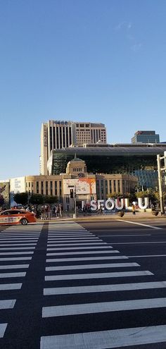 an intersection with cars and buildings in the background