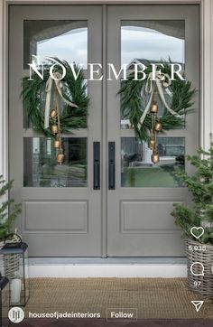 two christmas wreaths hanging on the front door of a house with no november written above them