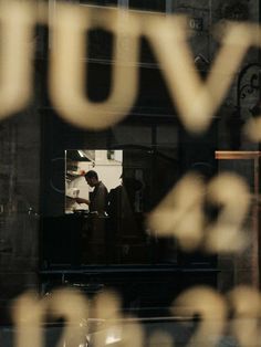 the reflection of two people in a window