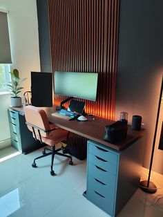 a desk with a computer monitor, keyboard and mouse on it in front of a window