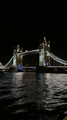 the tower bridge is lit up at night