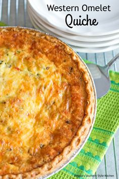 a quiche sitting on top of a table next to some plates and utensils