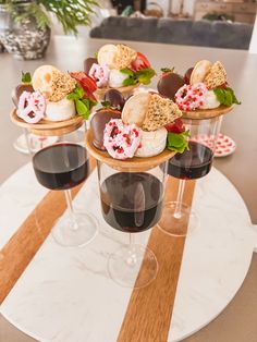 three wine glasses filled with desserts on top of a table