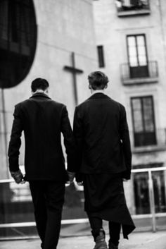 two men in suits walking down the street