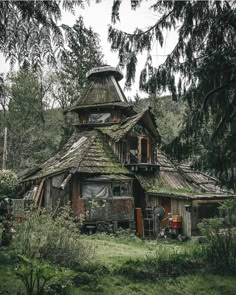 an old house in the woods with moss growing on it's roof and windows