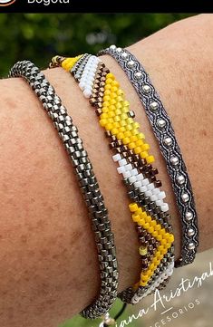 the bracelets are decorated with different colors and designs on each arm, along with silver beads