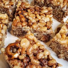 several pieces of dessert sitting on top of a white plate covered in nuts and chocolate